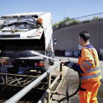 Mann spritzt Ladefläche des Schienenreinigungsfahrzeug ab