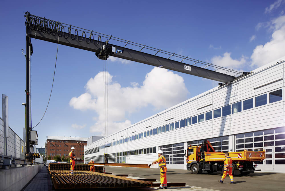 Bauarbeiter stapeln lange Eisenstangen mithilfe eines Krans
