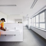 Bauarbeiter wäscht sich am Waschbecken im Gemeinschaftsbad die Hände