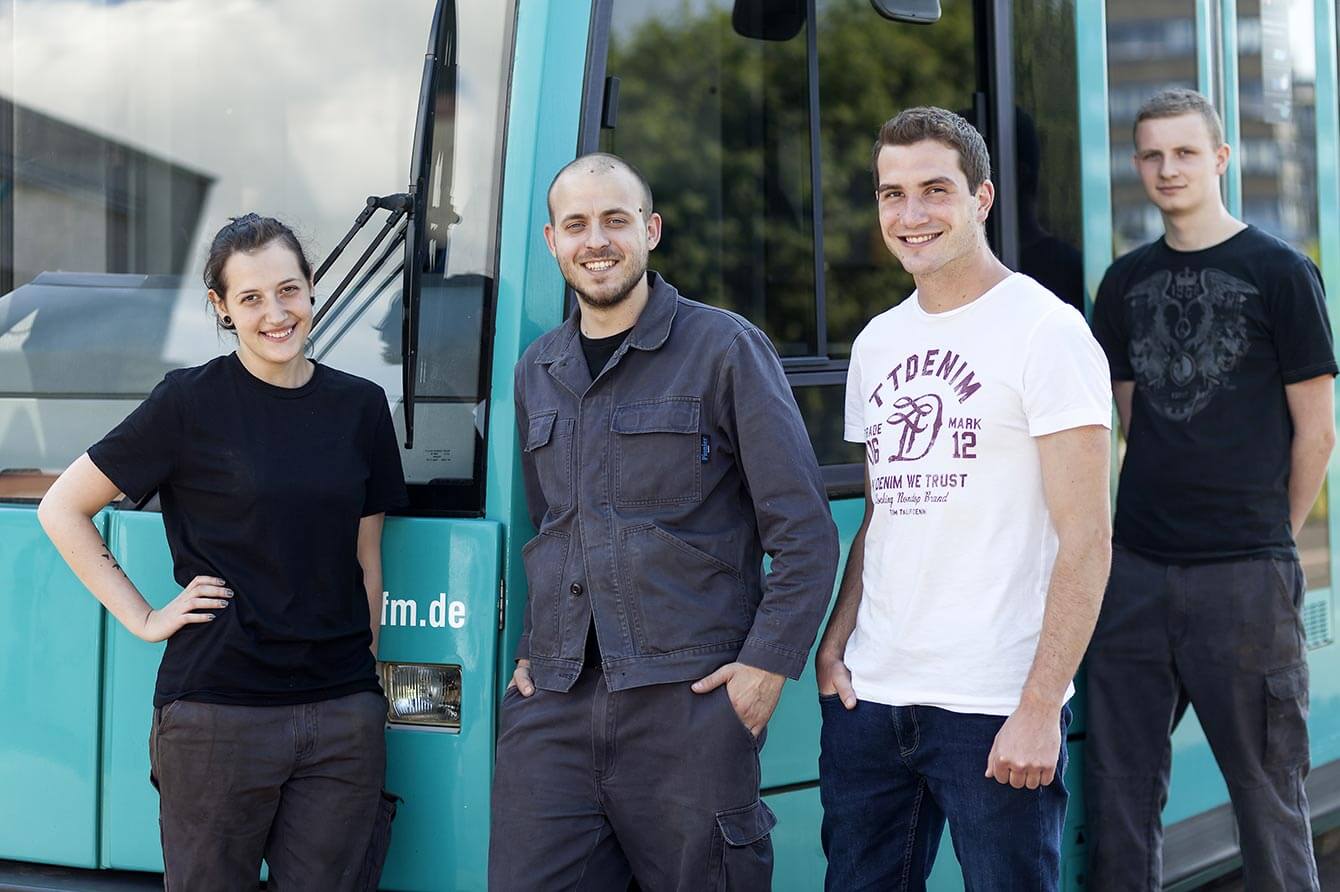 Vier Junge Menschen vor einer VGF Bahn lächeln in die Kamera