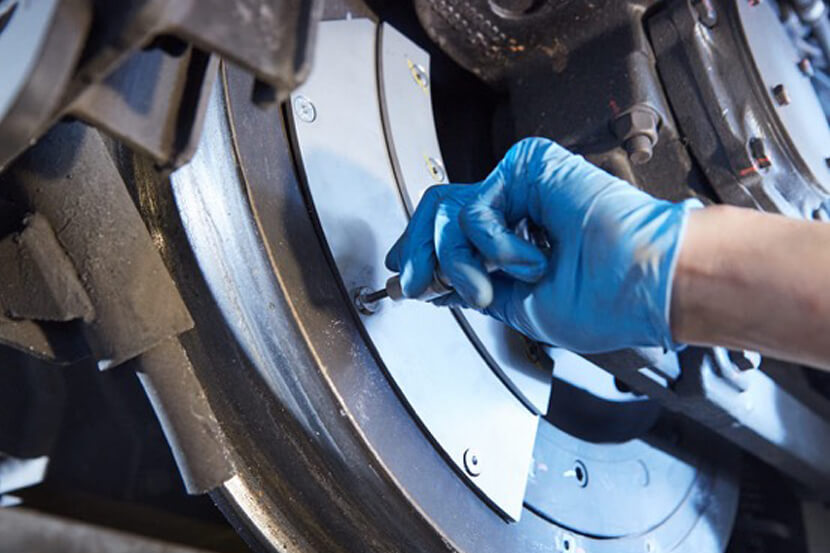 Ausschnitt: Person bei der Arbeit am Wagonrad