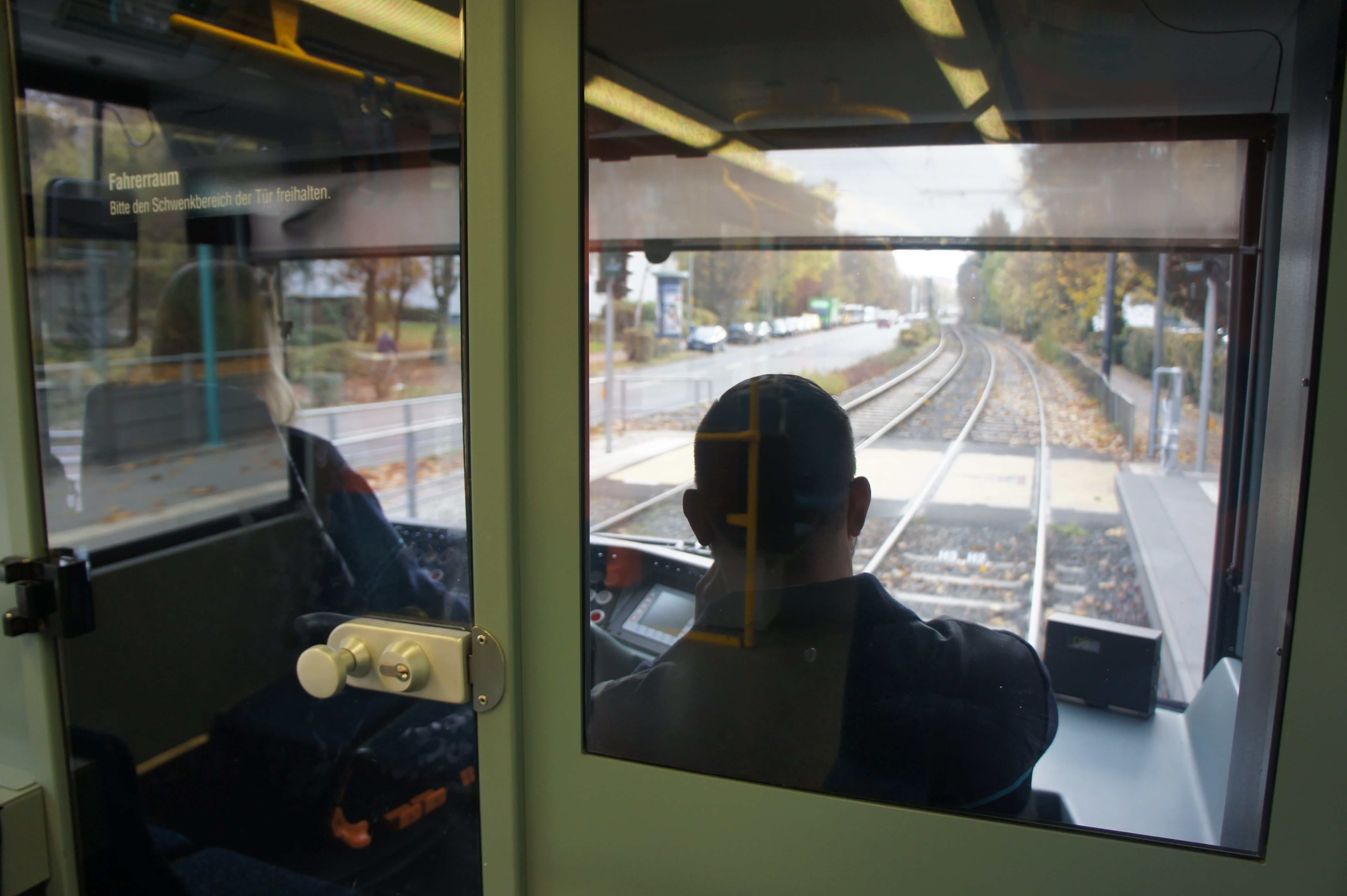 Zwei Mitarbeiter im Fahrerhäuschen bei der Fahrt.