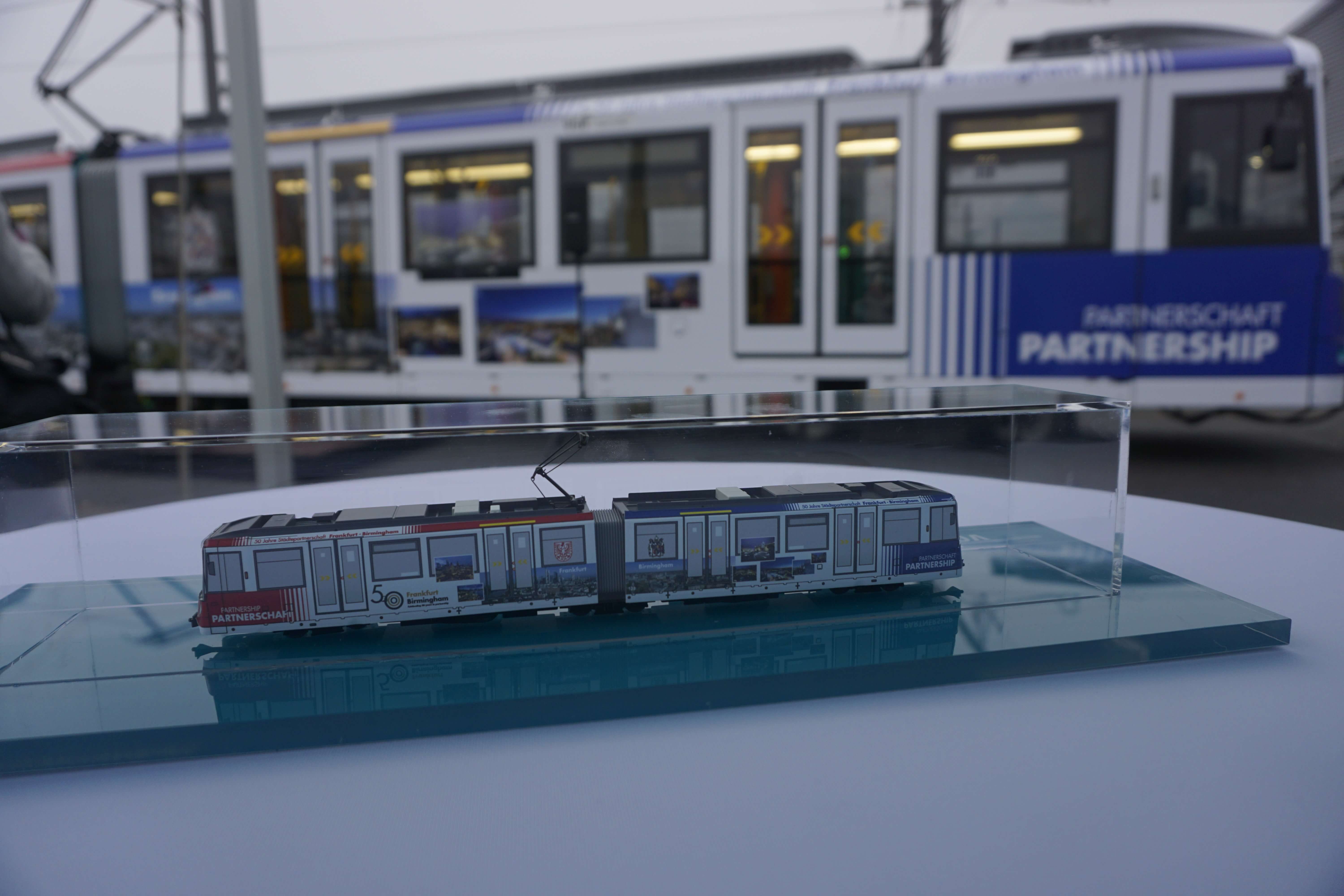 Bahn Modell in einem Glasgehäuse auf einem Tisch vor einer Bahn