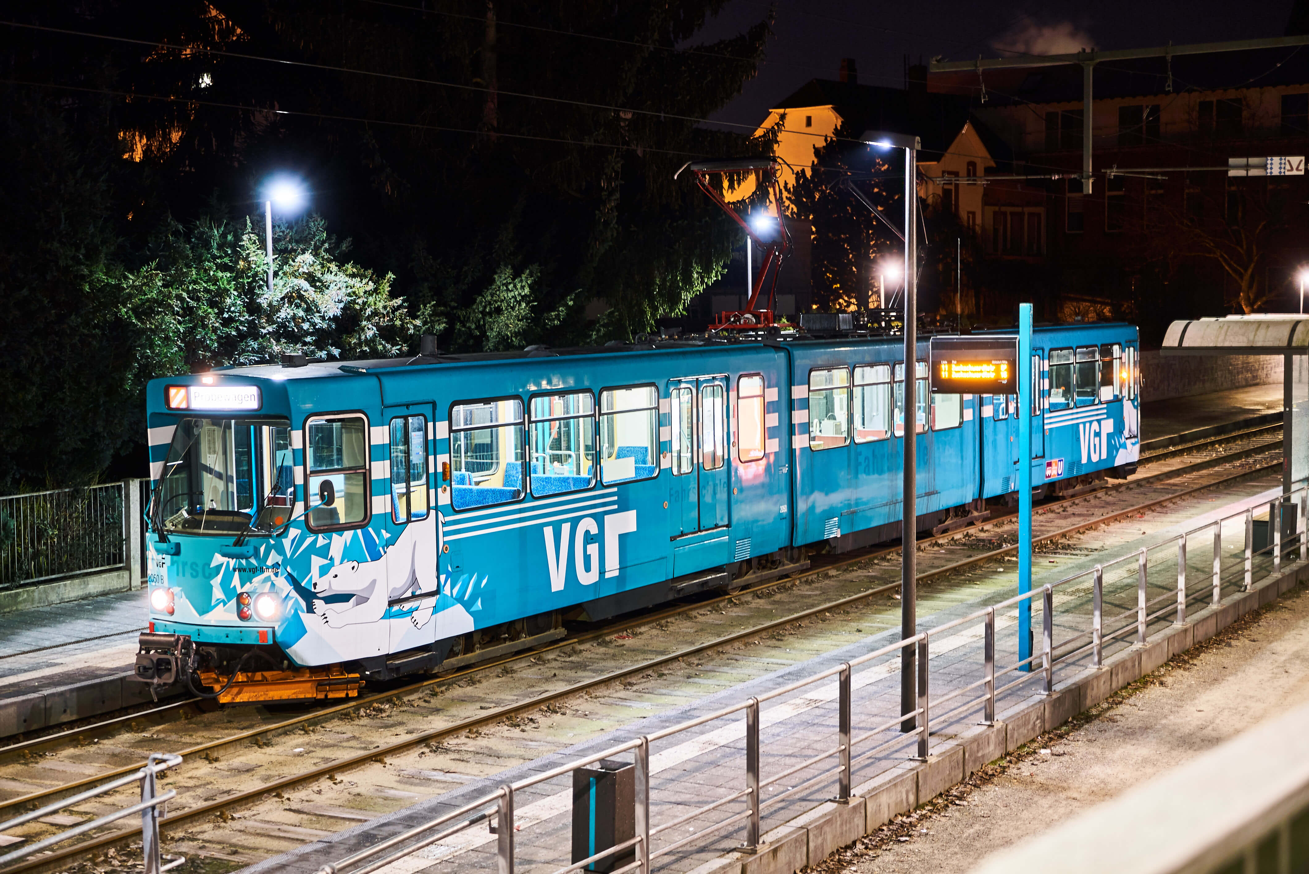 Schneeschieber-Bahn am einer Haltestelle bei Nacht.