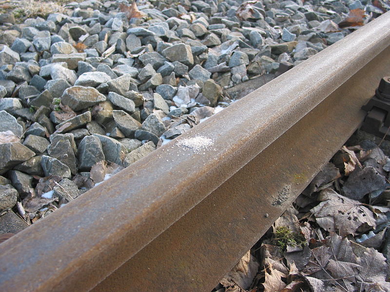 Nahaufnahme einer Schiene auf Schotter