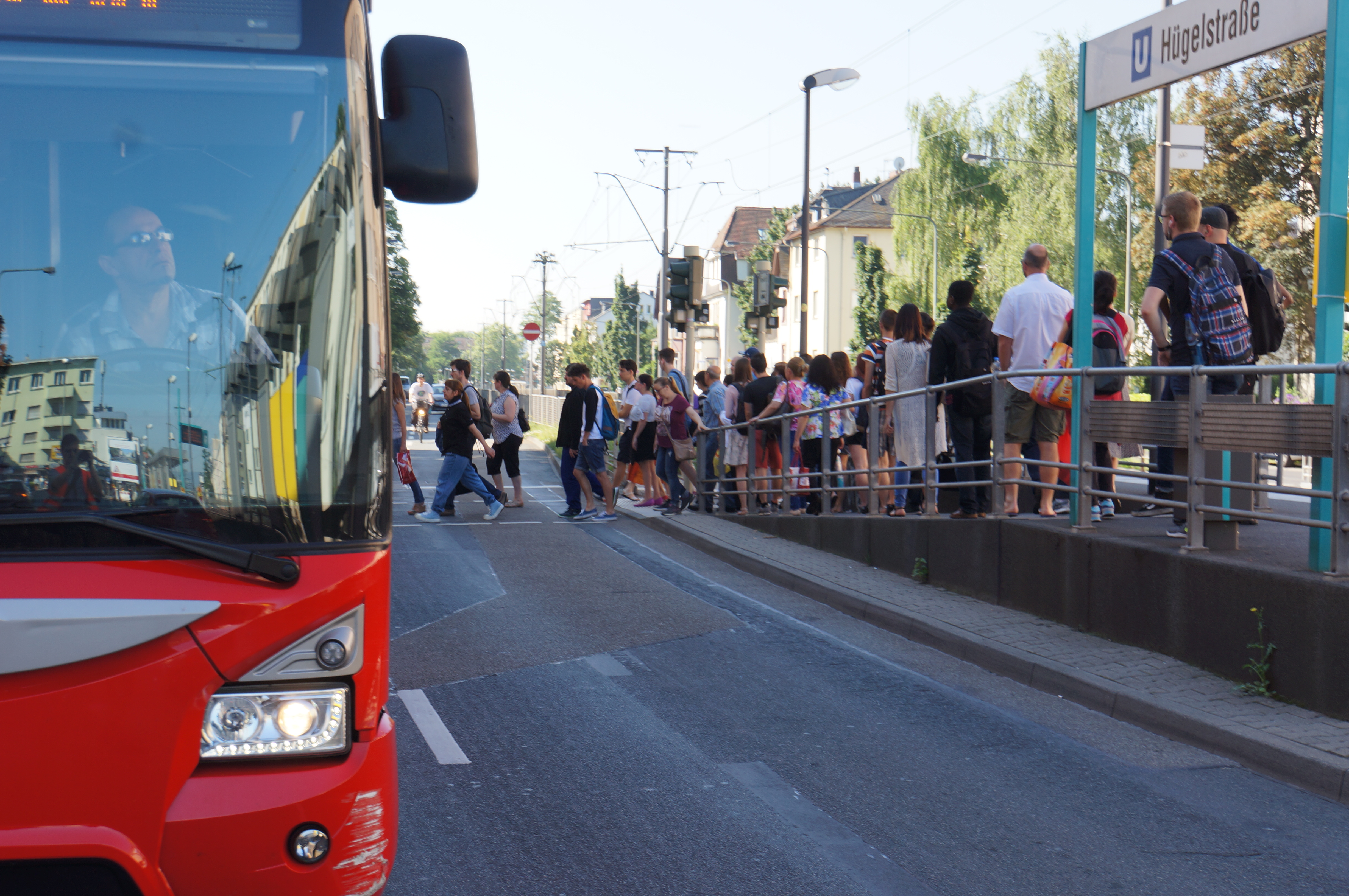 Fahrgäste auf dem Weg vom Bahnsteig der Haltestelle "Hügelstraße" auf den Bürgersteig