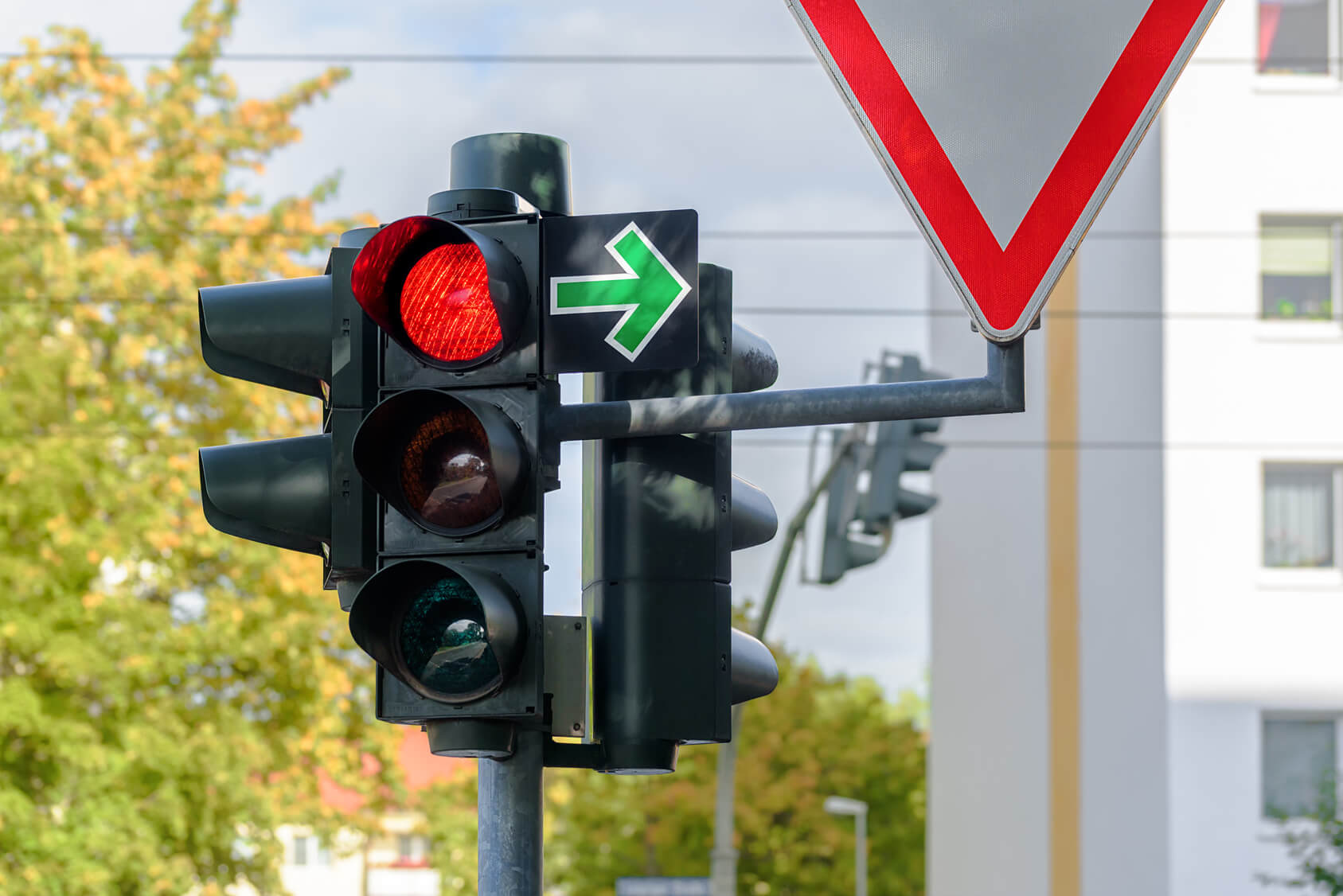 Rote Ampel mit grünem Pfeil nach rechts und einem Vorfahrt-Achten-Schild