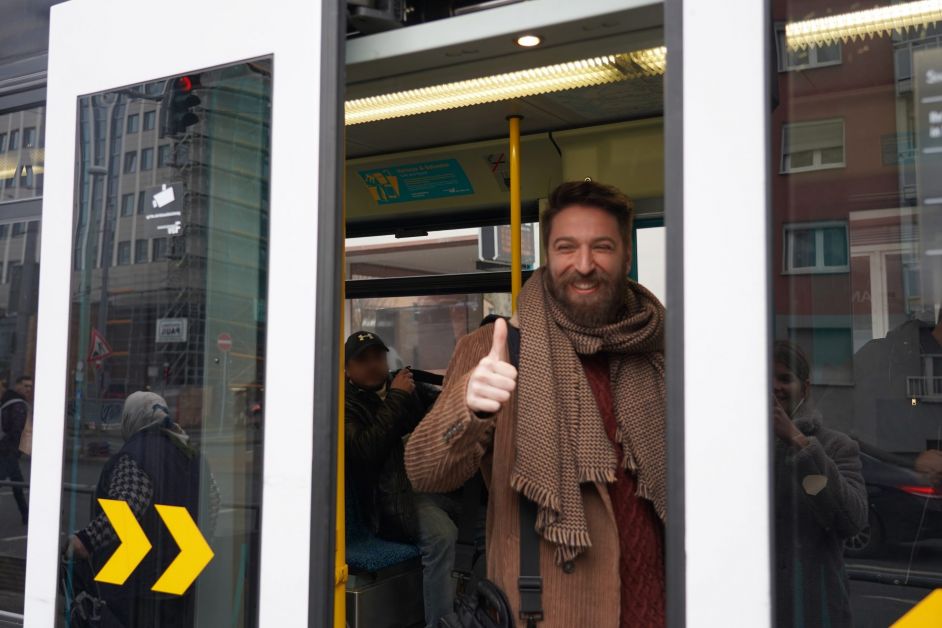 Ferhat, ein Mann, steht mit Daumen hoch in der Straßenbahn